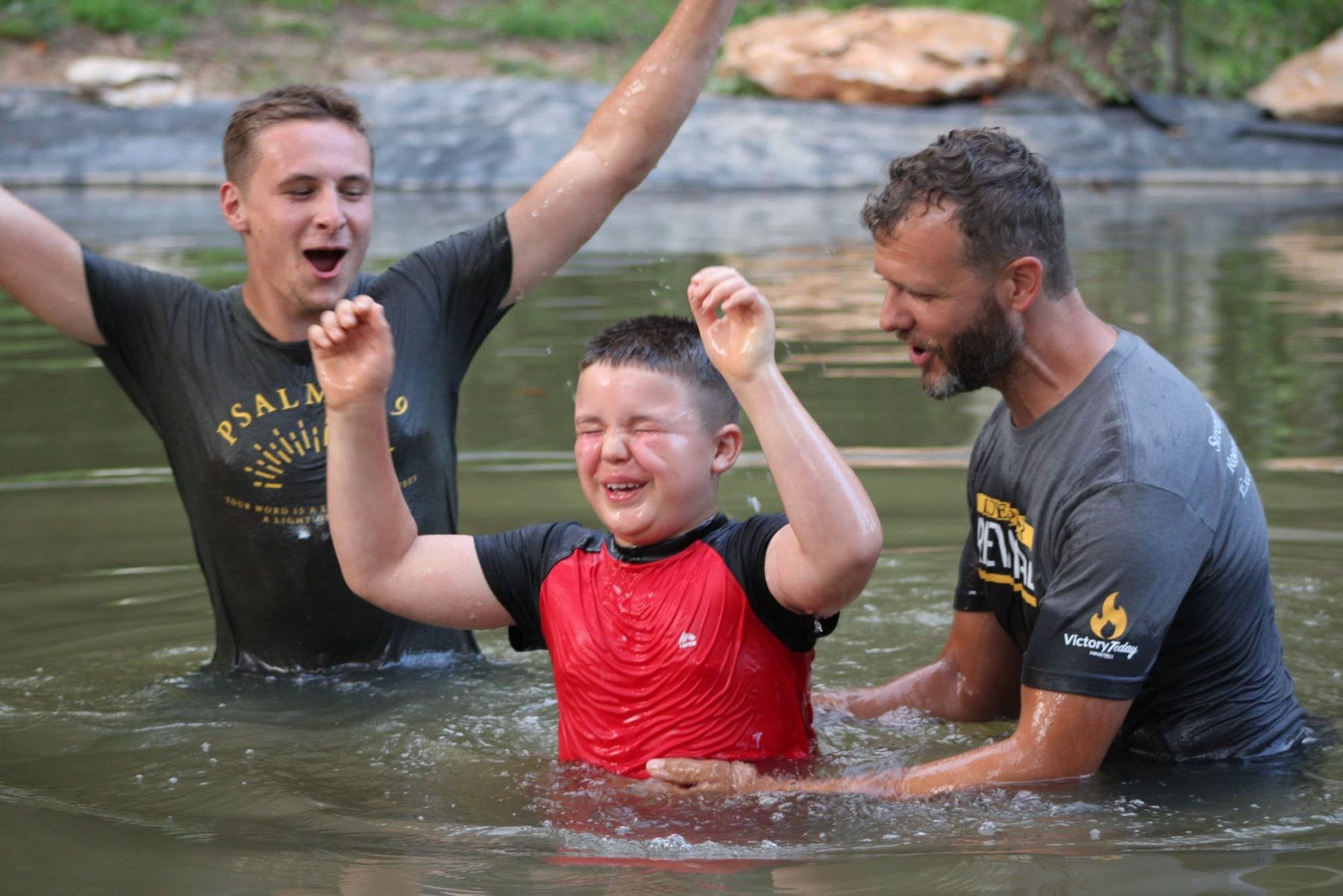 A boy being baptized in a river