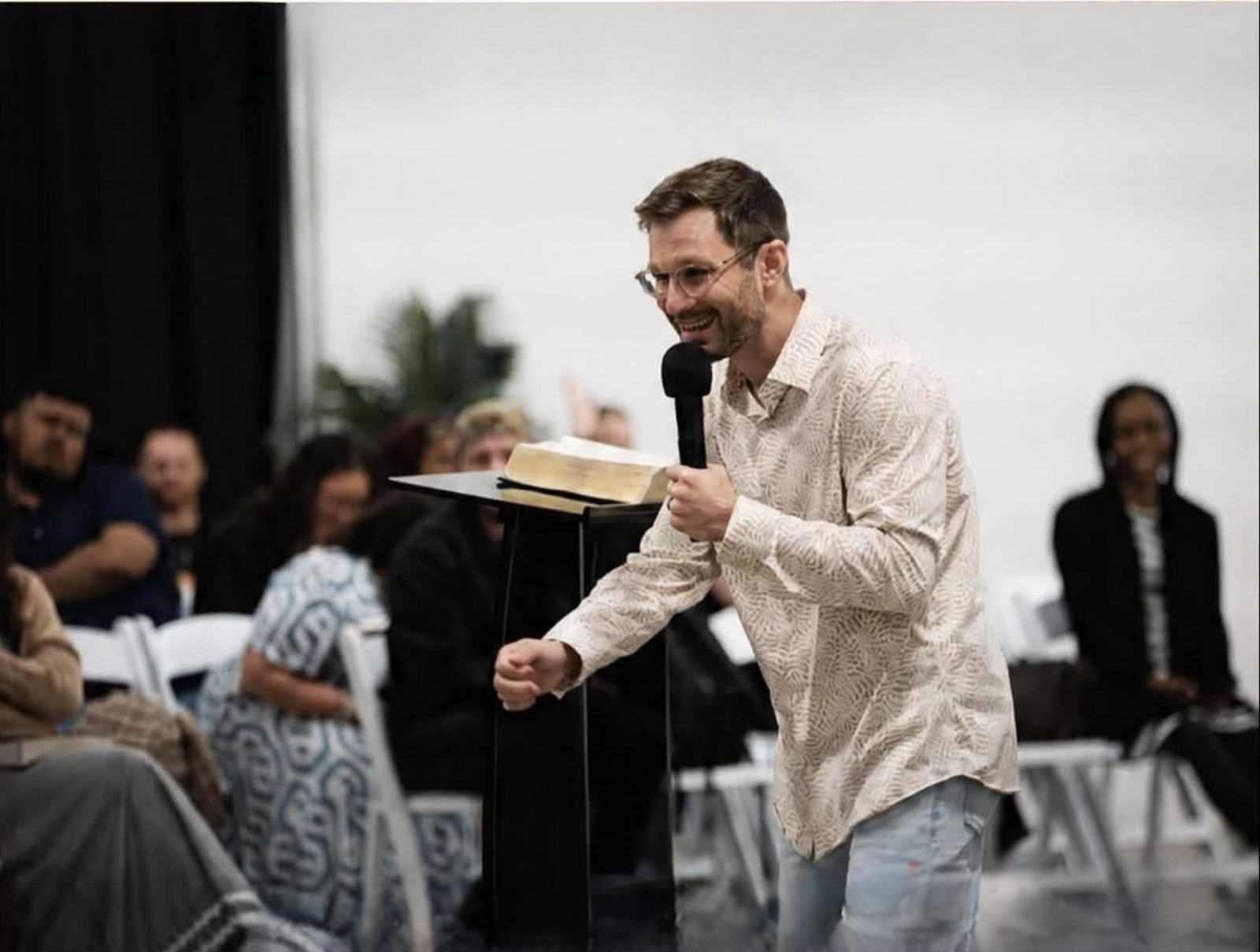 Pastor preaching with microphone and Bible